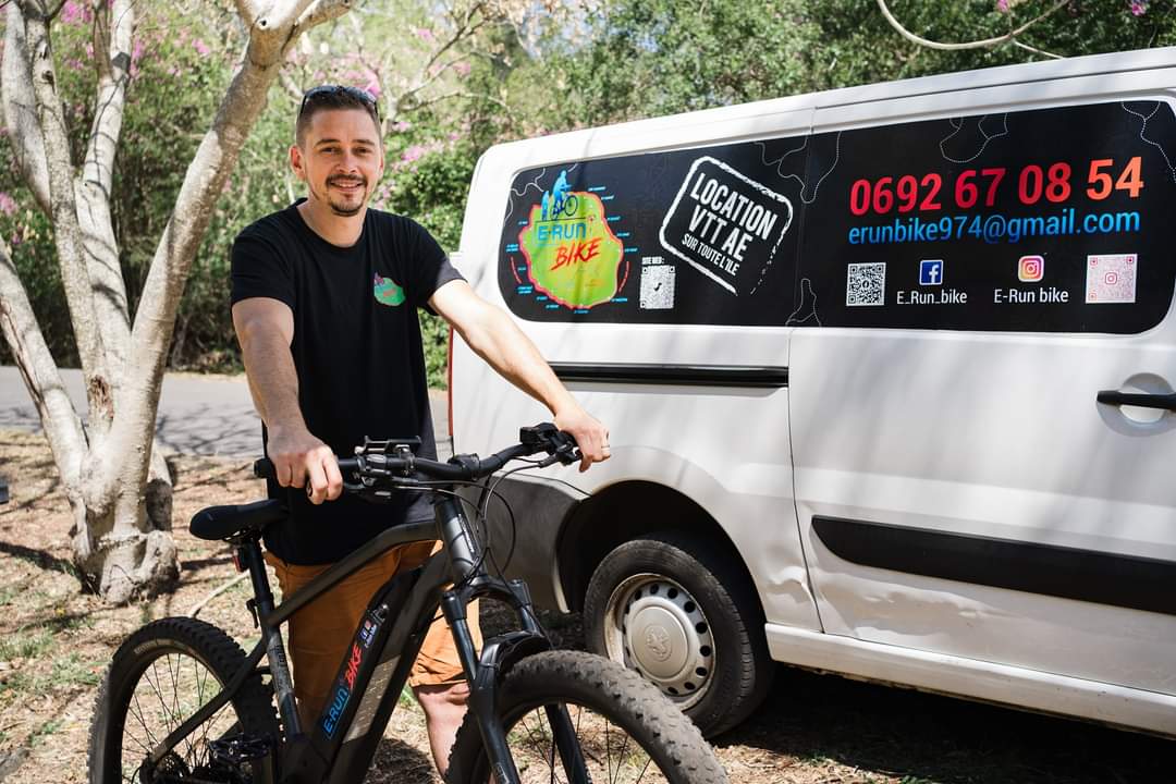Cyril et un VTT devant le véhicule atelier E‑Run Bike